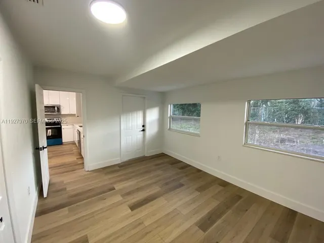 a view of empty room with wooden floor