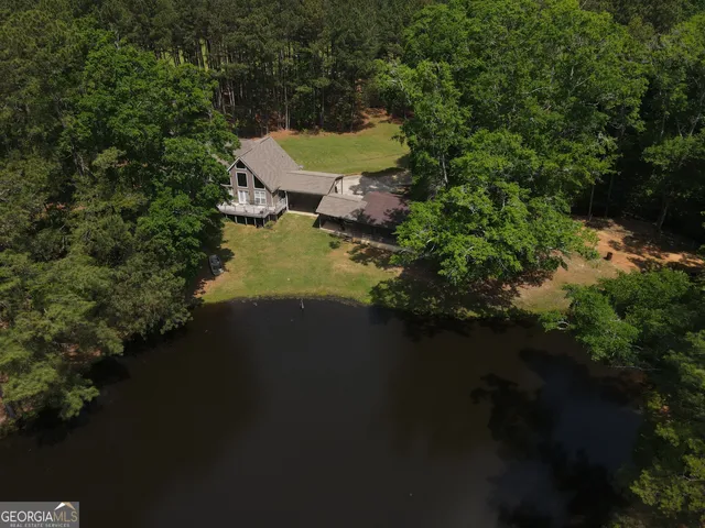 an aerial view of a house with garden space and lake view