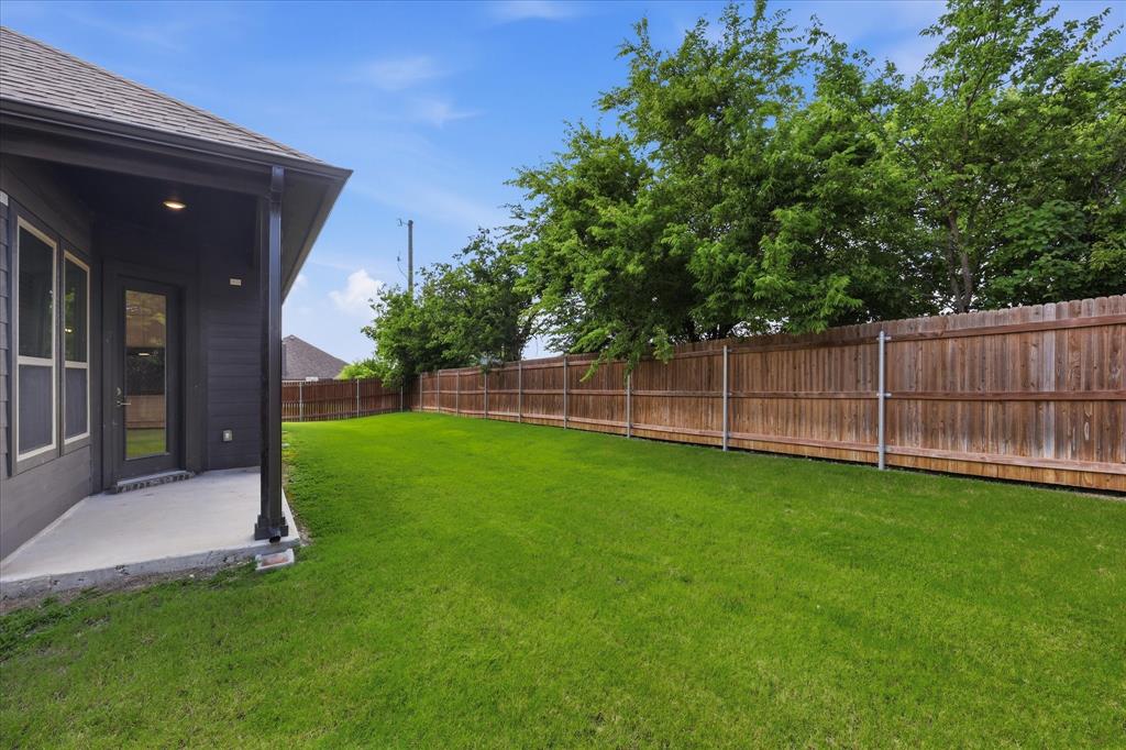 4017 Alpine Street Midlothian, TX 76065 - Photo 33 of 37 Spacious backyard featuring an expansive manicured lawn, a wood privacy fence, and mature trees