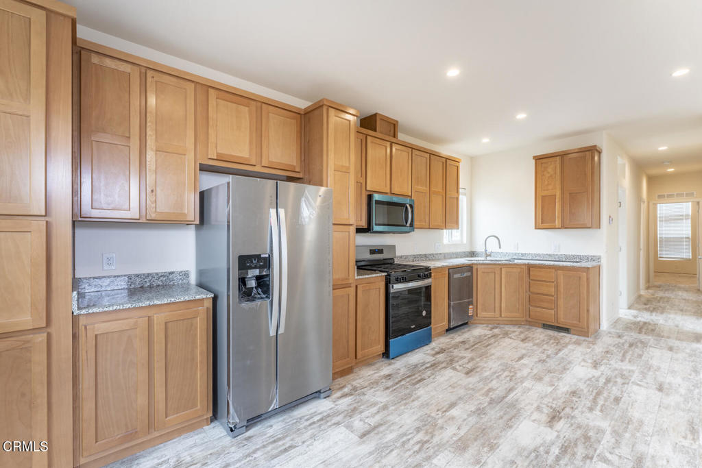 1021 South Main Street, Unit 2 Fort Bragg, CA 95437 - Photo 4 of 19 a kitchen with stainless steel appliances granite countertop a refrigerator and a stove top oven
