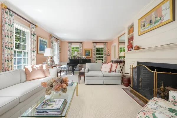 a living room with furniture a fireplace and a large window