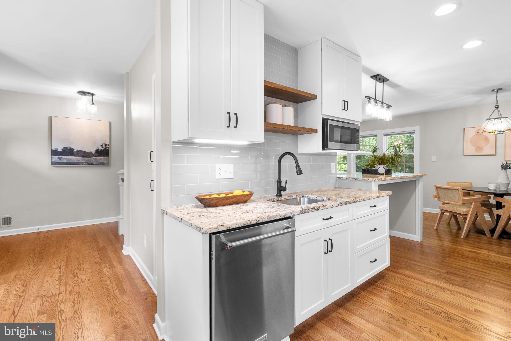 9907 Big Rock Road Silver Spring, MD 20901 - Photo 12 of 45 a kitchen with stainless steel appliances granite countertop a stove a sink dishwasher and a refrigerator with wooden floor