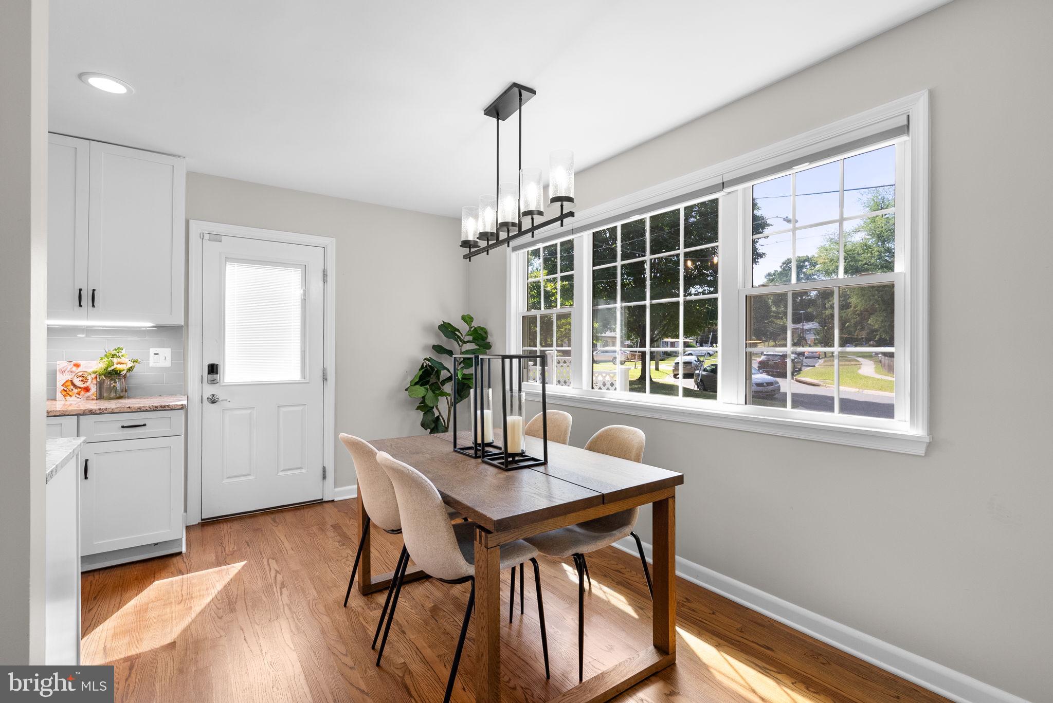 9907 Big Rock Road Silver Spring, MD 20901 - Photo 16 of 45 a dining room with wooden floor a chandelier a wooden table and chairs
