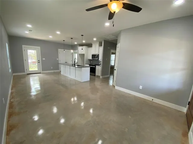 a view of kitchen with kitchen island stainless steel appliances refrigerator stove microwave and cabinets