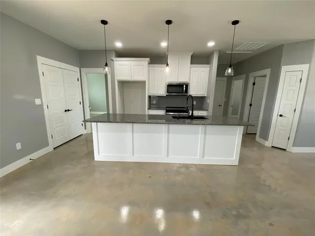 a large kitchen with stainless steel appliances a refrigerator and a sink