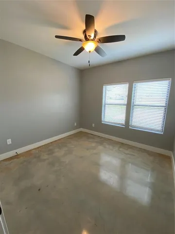 an empty room with a window and a ceiling fan