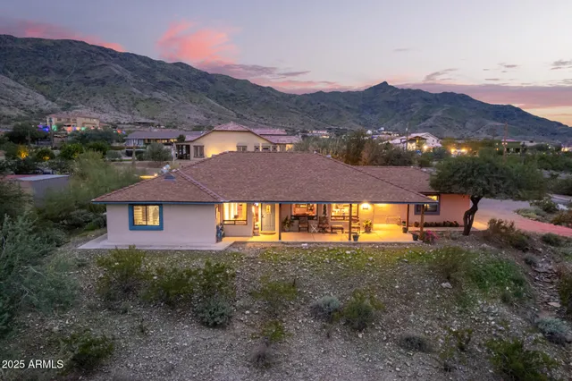 a front view of a house with a yard and a mountain
