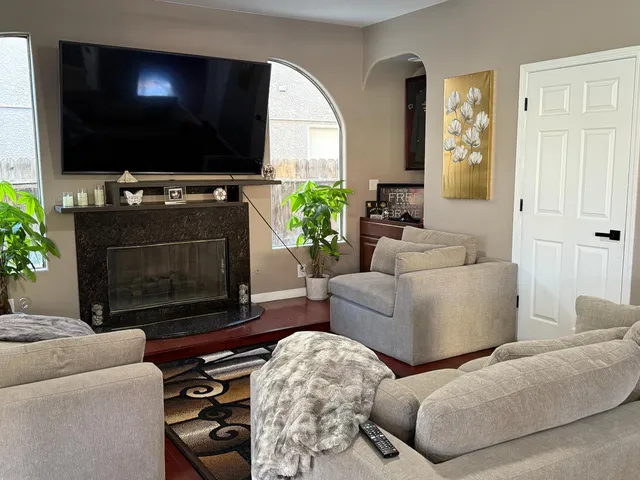 a living room with furniture a flat screen tv and a fireplace