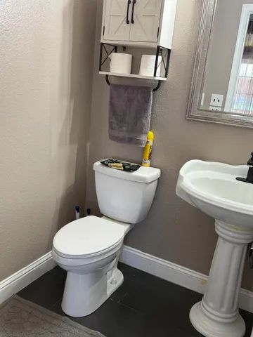 a white toilet sitting next to a bathroom sink