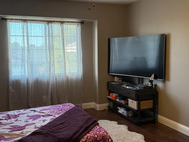 a bedroom with a bed and a flat screen tv