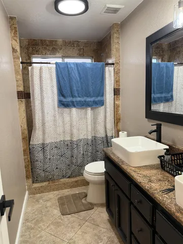 a bathroom with a granite countertop sink toilet and shower