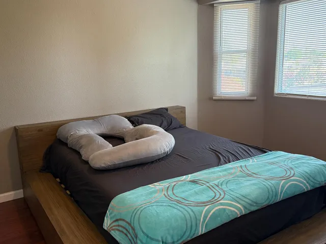 a bed sitting in a bedroom next to a window