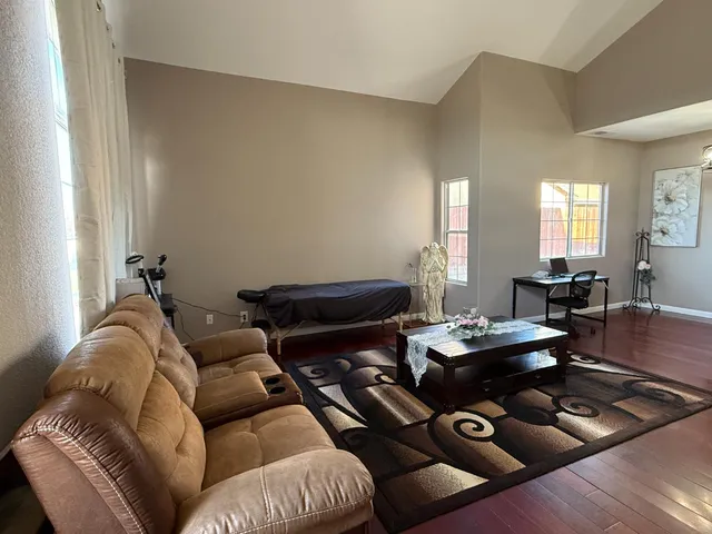 a living room with furniture and wooden floor