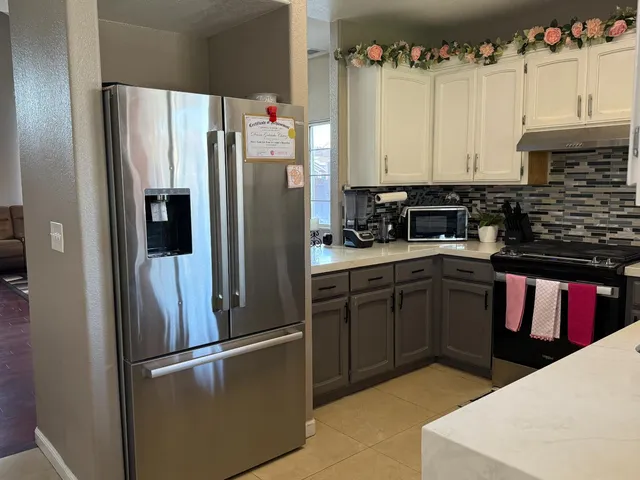 a kitchen with a refrigerator sink and cabinets