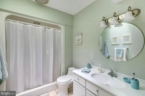 a bedroom with a large bed and a flat tv screen on dresser