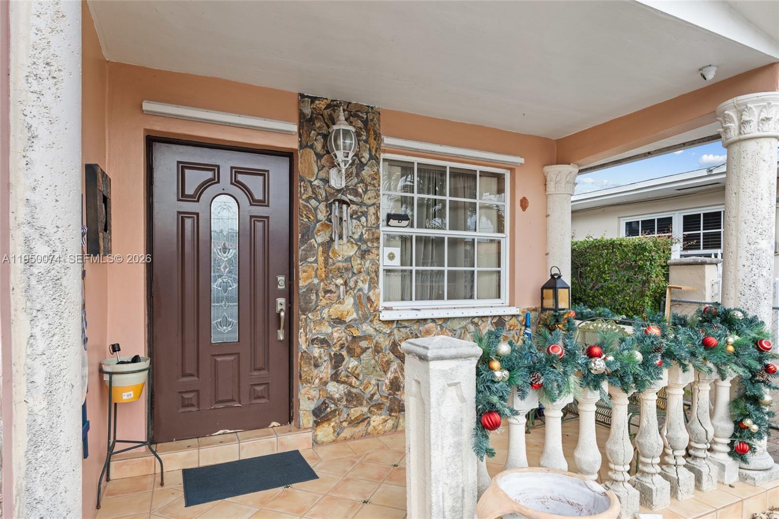 5951 Southwest 4th Street Miami, FL 33144 - Photo 3 of 23 front view of a house with a potted plant and a window