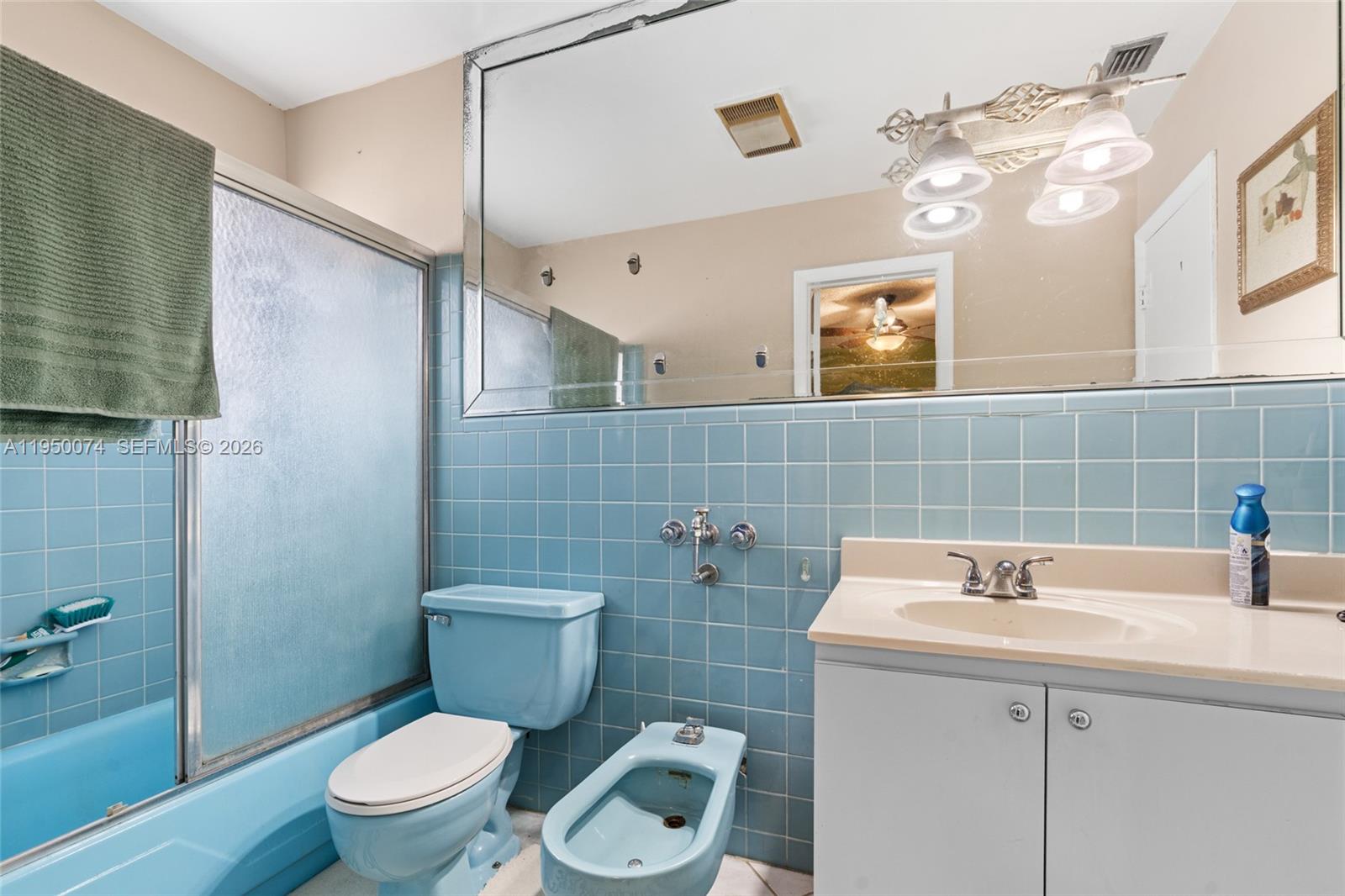 5951 Southwest 4th Street Miami, FL 33144 - Photo 7 of 23 a bathroom with a sink a toilet and mirror