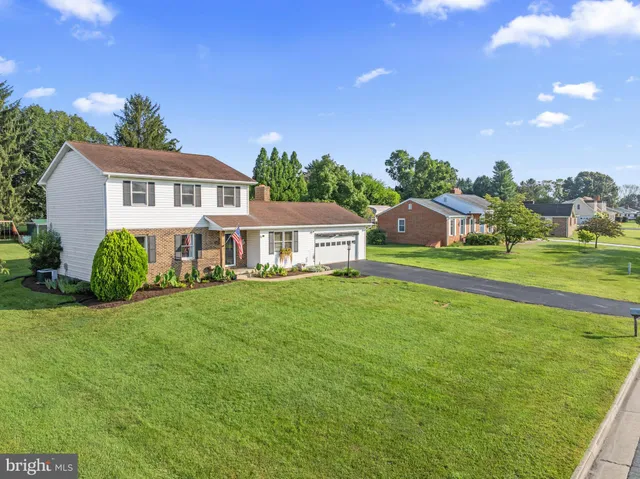 a view of a patio with couches table and chairs under an umbrella