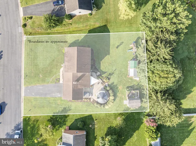 an aerial view of residential houses with outdoor space and trees