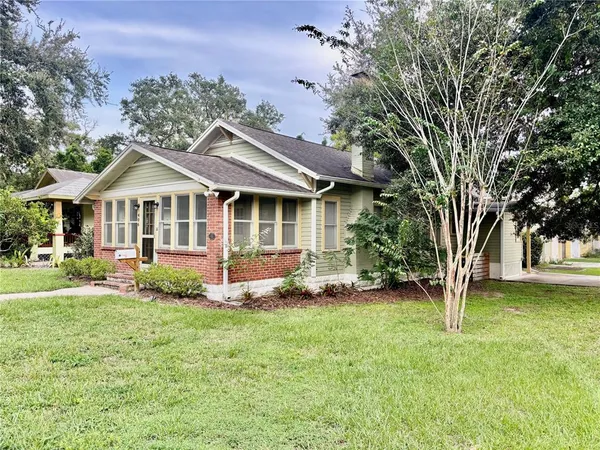 a front view of a house with a yard and trees