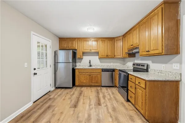 a kitchen with refrigerator cabinets and wooden floor