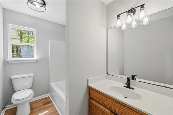 a bathroom with a sink a toilet and a mirror