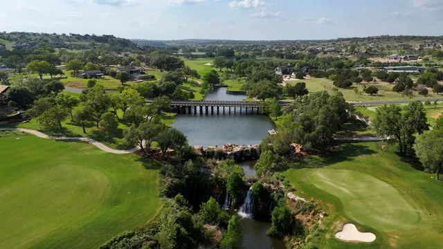 an aerial view of residential houses with outdoor space and trees