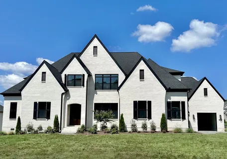 a front view of house with a garden