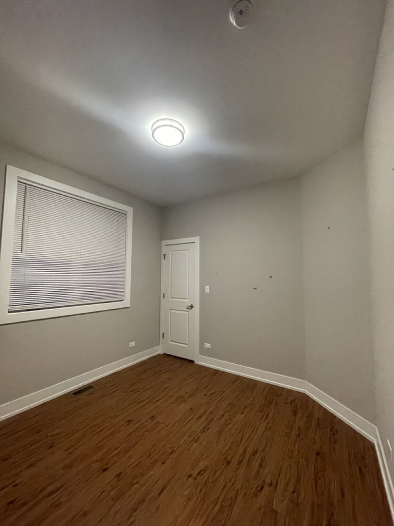 215 South Hamilton Avenue, Unit 1N Chicago, IL 60612 - Photo 11 of 23 a view of an empty room with wooden floor and a window