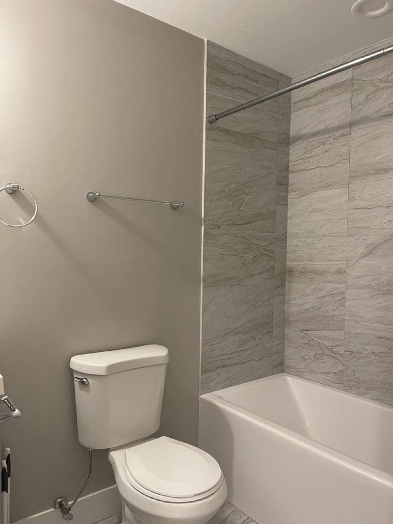 215 South Hamilton Avenue, Unit 1N Chicago, IL 60612 - Photo 20 of 23 a white toilet and tub sitting next to a bathroom sink