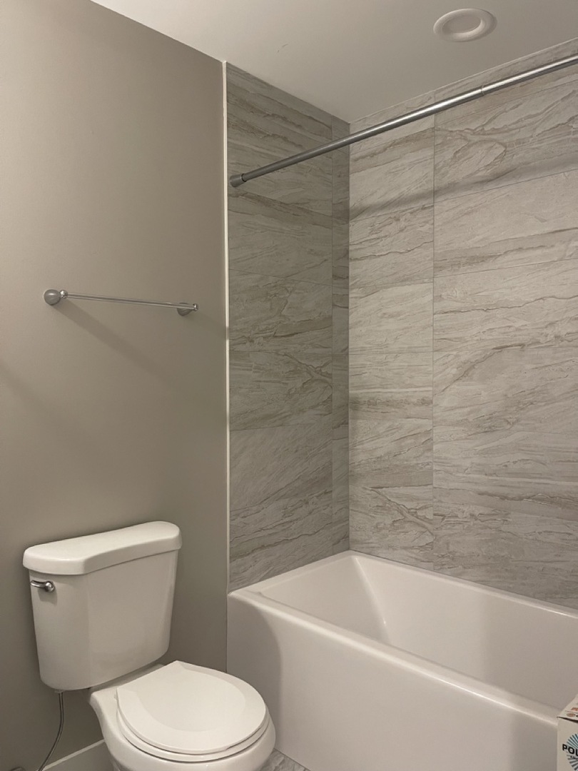 215 South Hamilton Avenue, Unit 1N Chicago, IL 60612 - Photo 21 of 23 a white toilet and tub sitting next to a bathroom sink