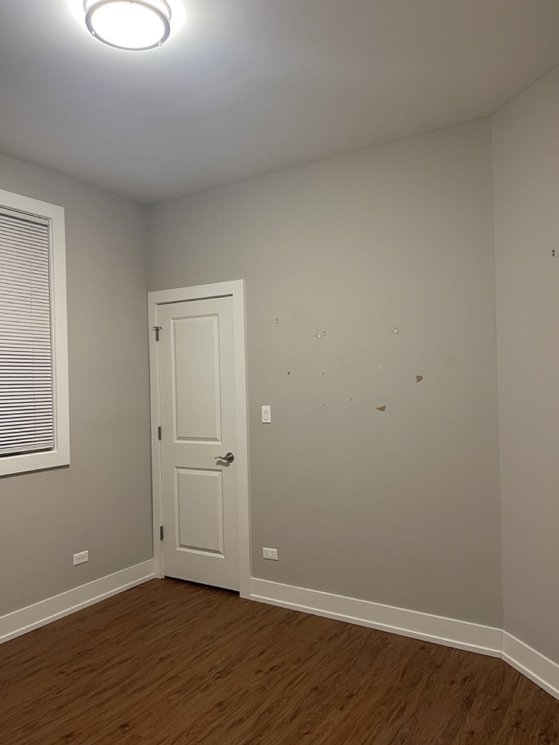 215 South Hamilton Avenue, Unit 1N Chicago, IL 60612 - Photo 10 of 23 a view of an empty room with wooden floor and a window