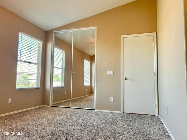 an empty room with windows and closet