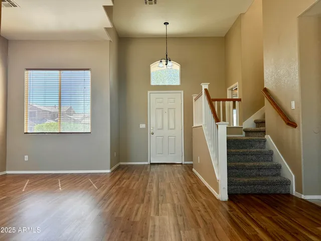 a view of a hallway with wooden floor and stairs