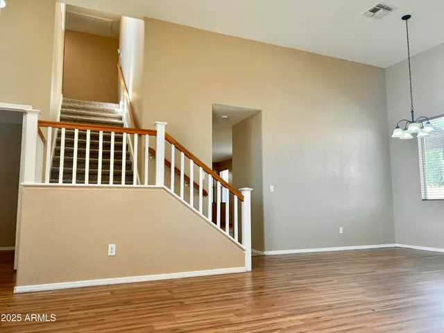a view of a livingroom with wooden floor and staircase
