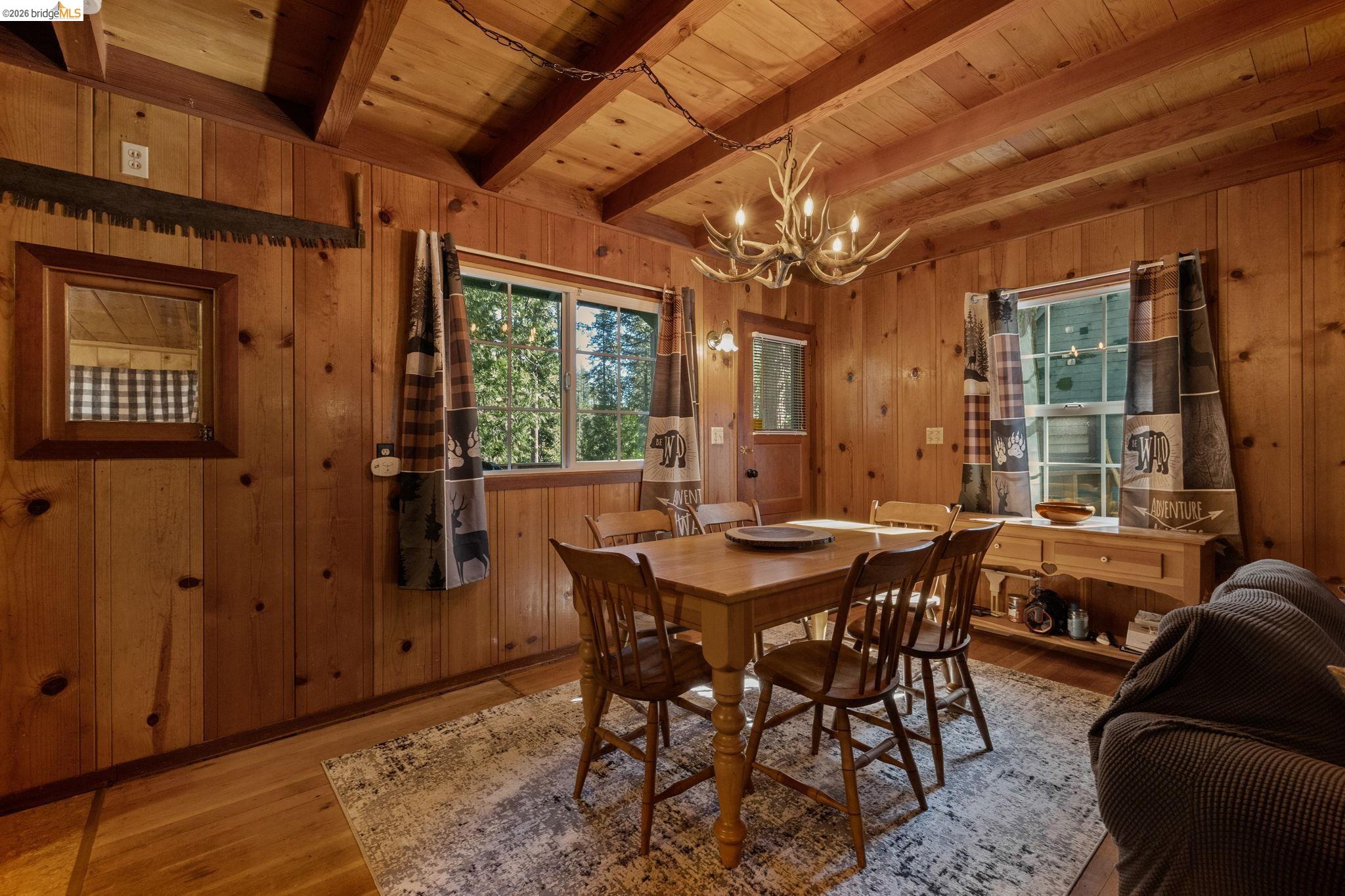26175 Janice Way Long Barn, CA 95335 - Photo 5 of 23 Dining space featuring wood finished floors, wood walls, a chandelier, and a wooden ceiling with exposed beams
