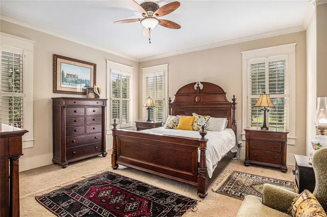 a bedroom with a bed and large windows