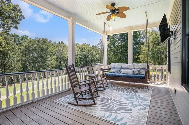 a living room with furniture a flat screen tv and a chandelier