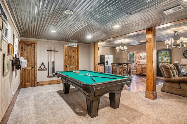 a view of a chairs and table in the patio next to a yard