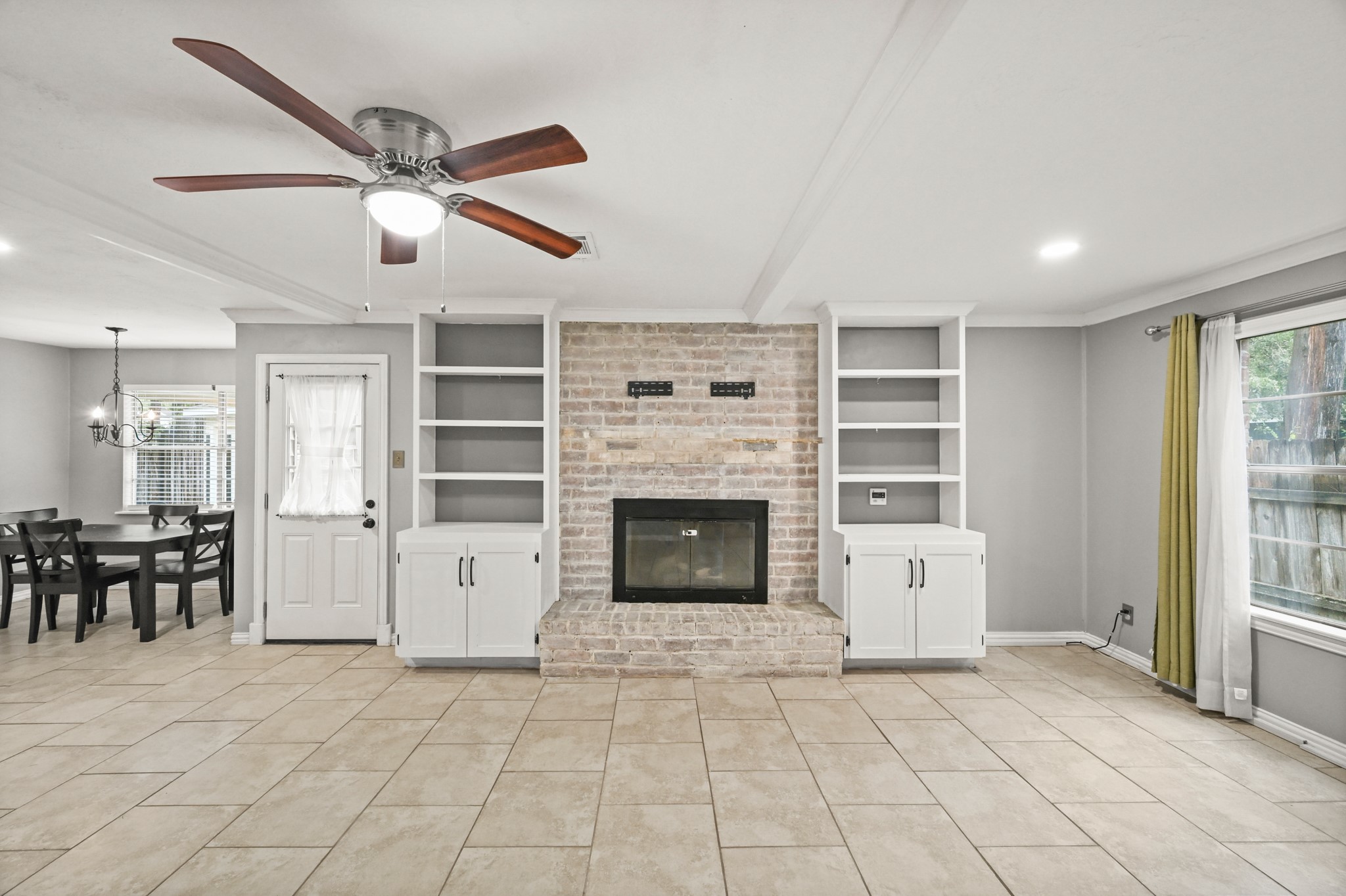 7618 Fountaingrove Lane Spring, TX 77379 - Photo 5 of 20 Cozy living room with an electric fireplace and seamless flow into the breakfast area and kitchen—perfect for everyday comfort.