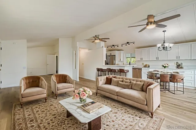 a living room with furniture kitchen view and a table