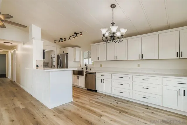 a view of a kitchen sink and dishwasher with wooden floor