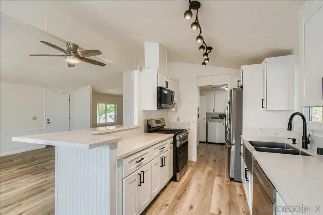 a kitchen with a stove and a wooden floor