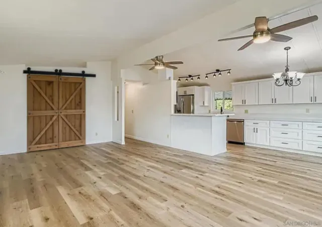 a view of a kitchen with wooden floor and a ceiling fan