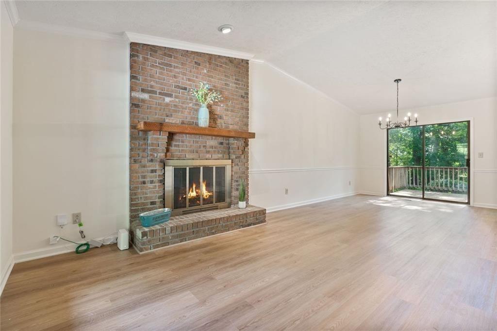 4534 Tifton Court Powder Springs, GA 30127 - Photo 4 of 23 an empty room with wooden floor fireplace and windows