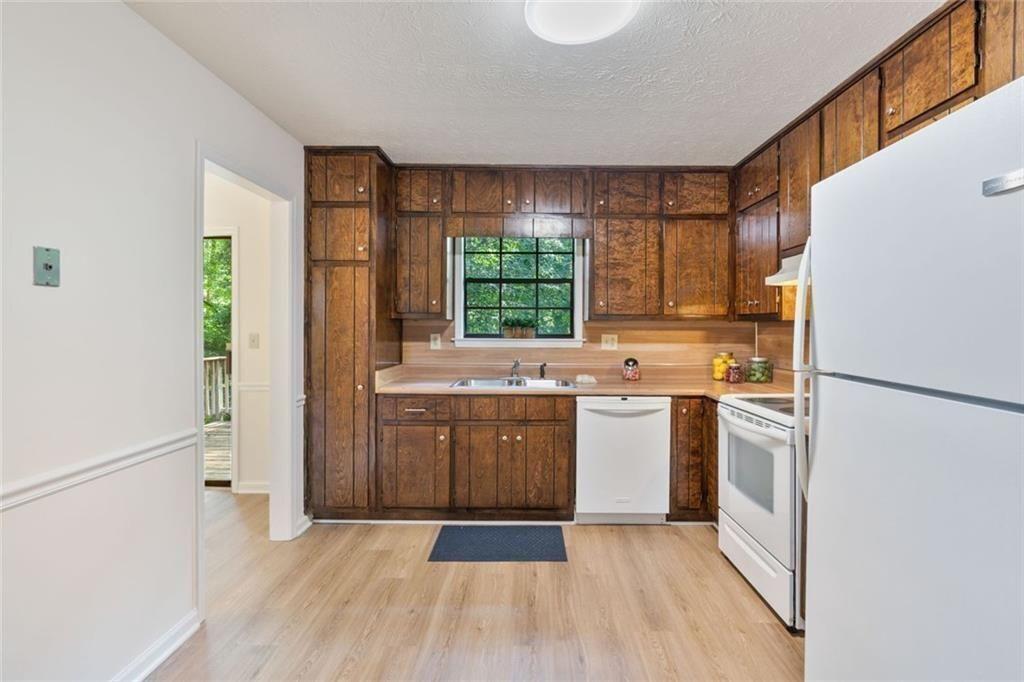 4534 Tifton Court Powder Springs, GA 30127 - Photo 10 of 23 a kitchen with a white stove top oven and refrigerator