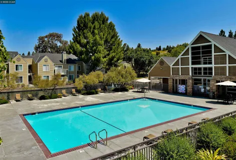a view of a house with pool and chairs