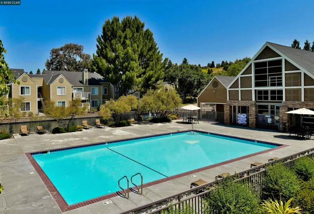 a view of a house with pool and chairs