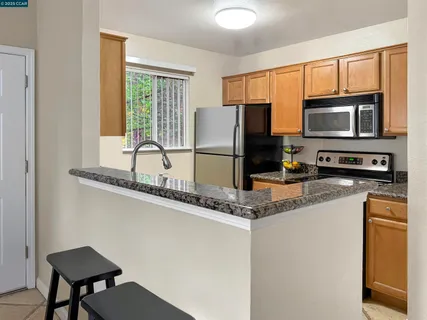 a kitchen with stainless steel appliances granite countertop a stove a sink and a microwave