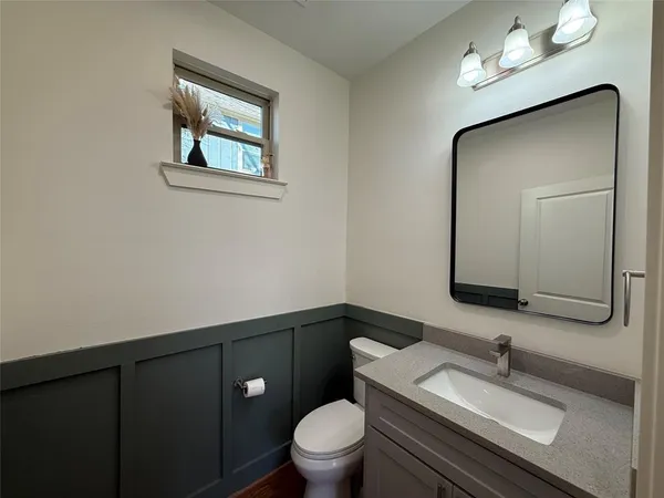 a bathroom with a toilet a sink and mirror